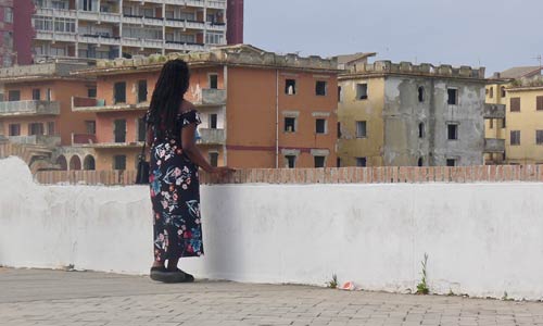 AU LENDEMAIN DE L'ODYSSÉE  -  Sabrina Efionayi dans le quartier de Castel Volturno  © Helen Doyle